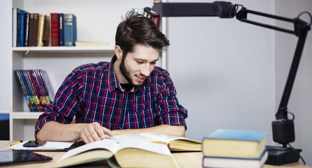 University students Student Reading Books at a Desk