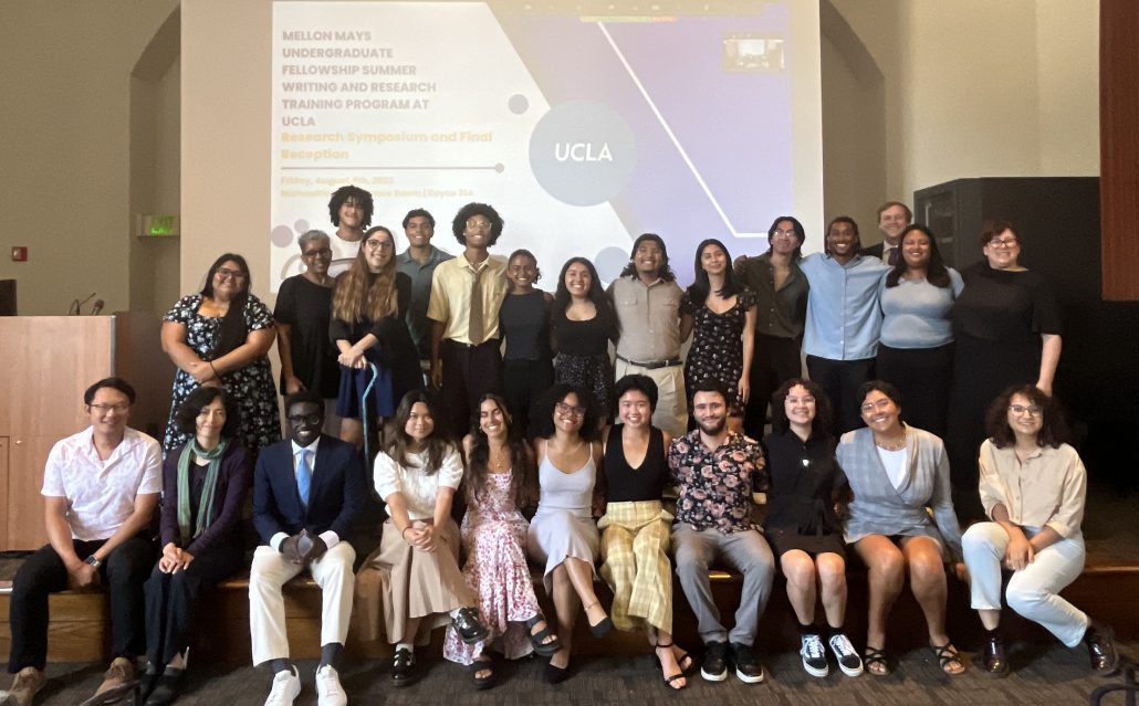 26 students and mentors in a group on a stage