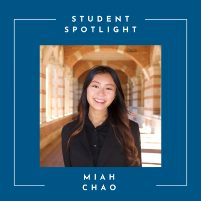 A young woman with long dark hair standing in the UCLA Royce Hall brick arches. She is wearing a black top.