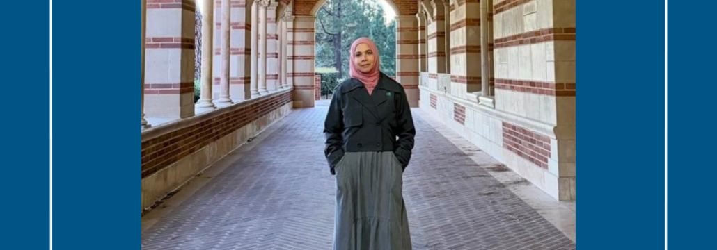 A woman standing under an arcage