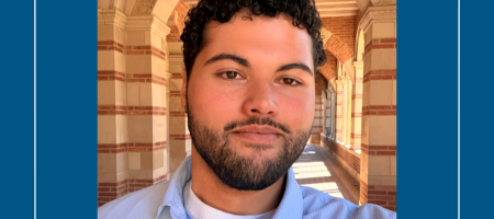 UCLA student with beard, standing in the Royce Hall arches.