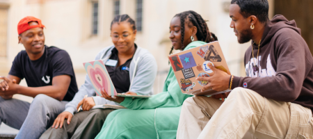 Four students sitting on steps and talking