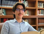 Young man in glasses in a library